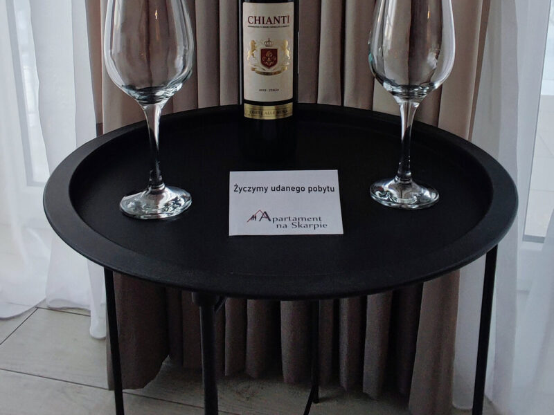 Stół powitalny z winem Chianti i kartką Życzymy udanego pobytu w apartamencie