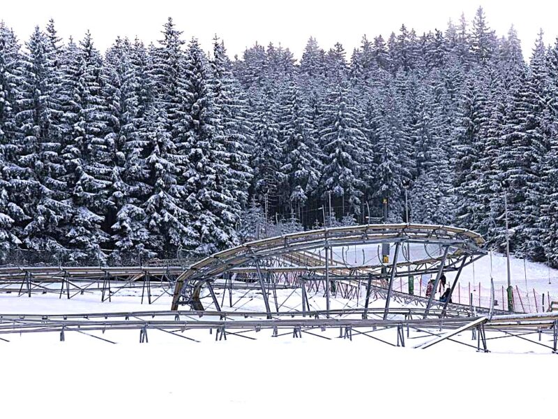 Tory alpine coasteru Czarna Żmija w Czarnej Górze zimą, otoczone zaśnieżonymi jodłami